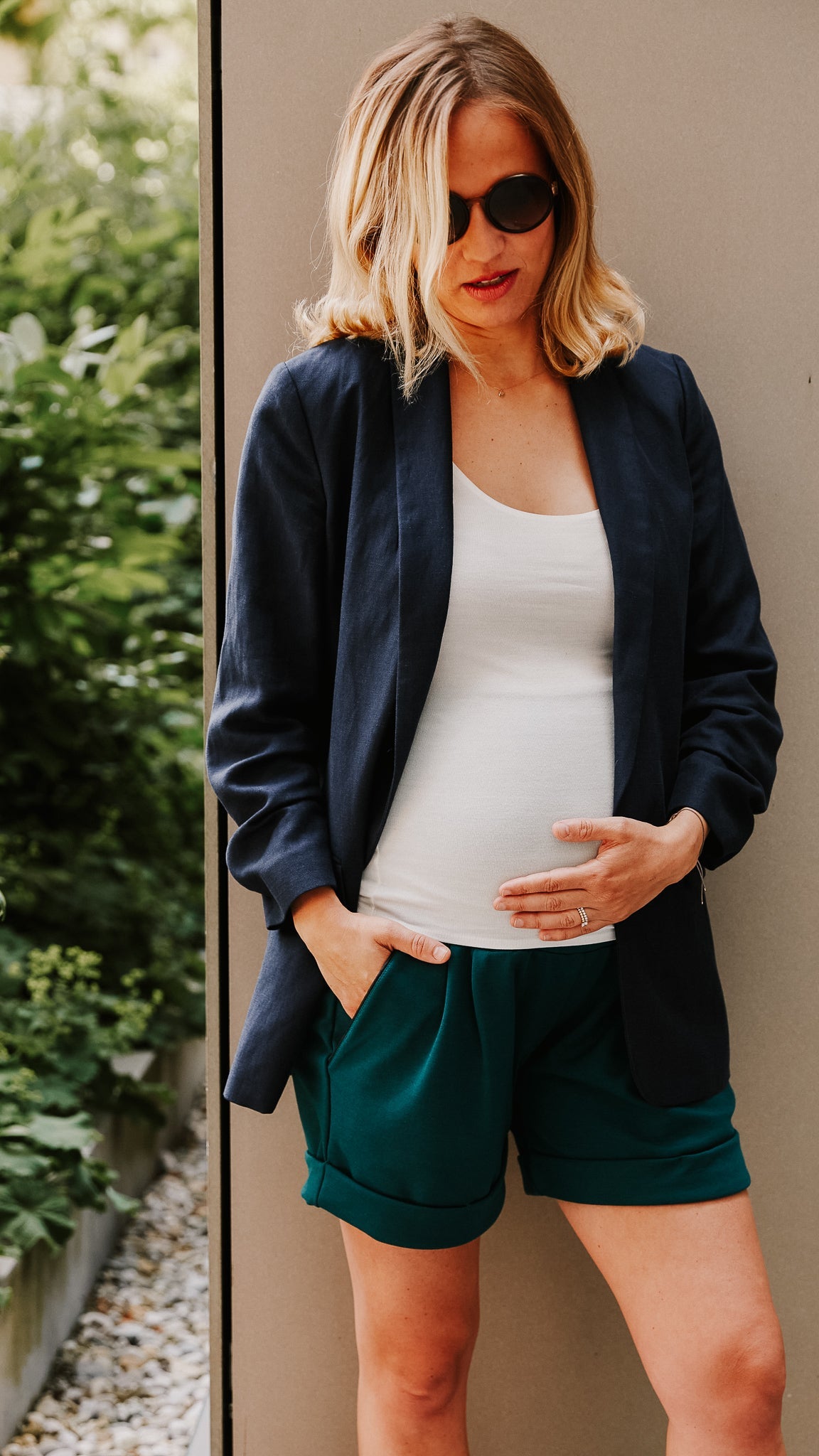 Nachhaltiger Schwangerschaftsblazer mit weißem Shirt und dunkelgrünen kurzen Hosen